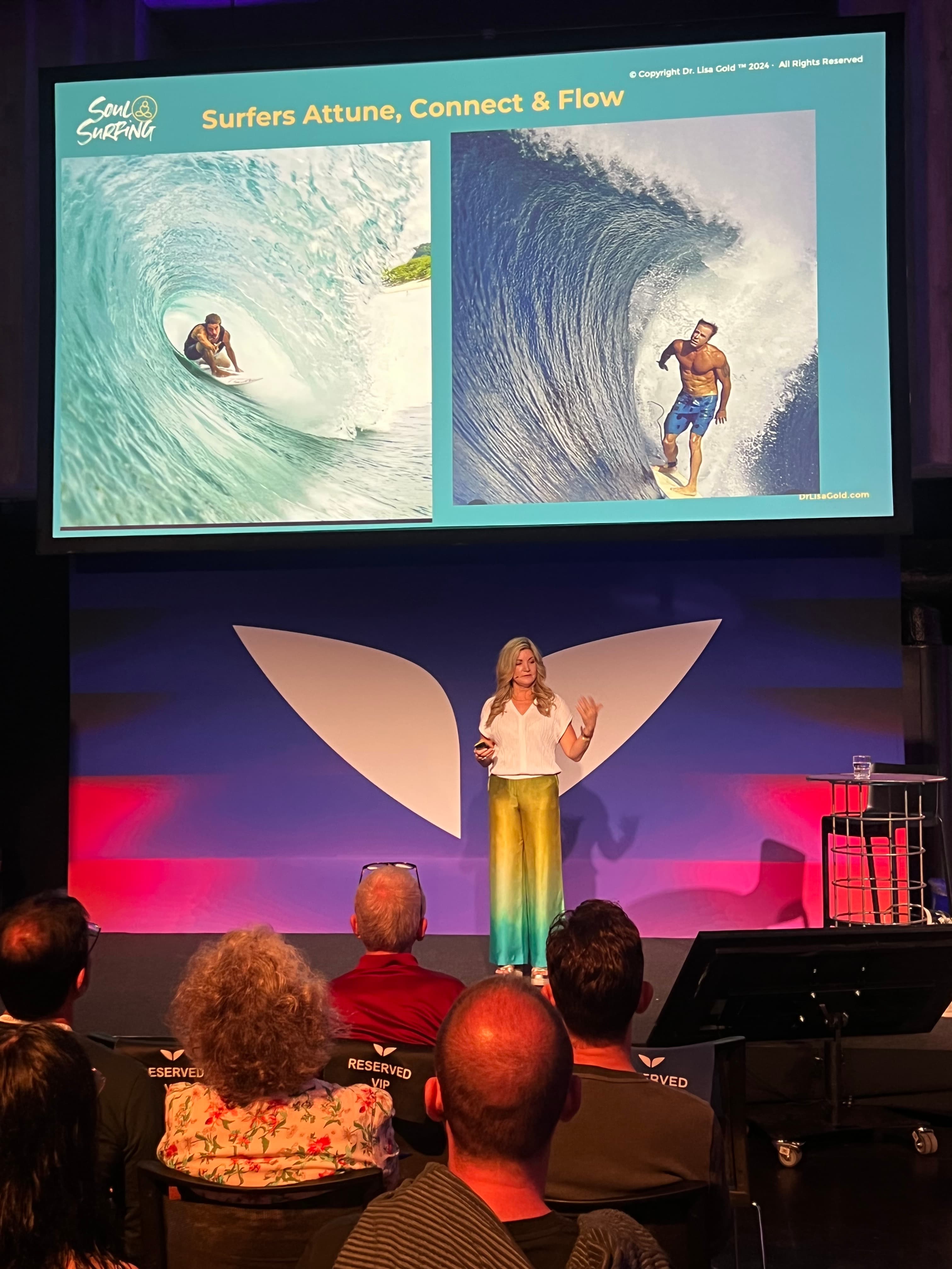 Dr. Lisa Gold speaking on stage at Mindvalley University